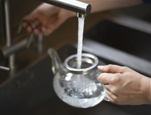 Une carafe en train de se remplir avec de l'eau du robinet 