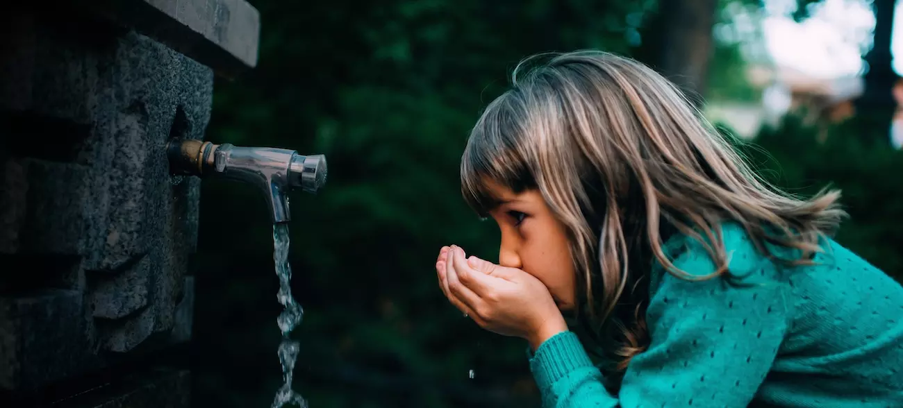 Enfant buvant l'eau de la fontaine