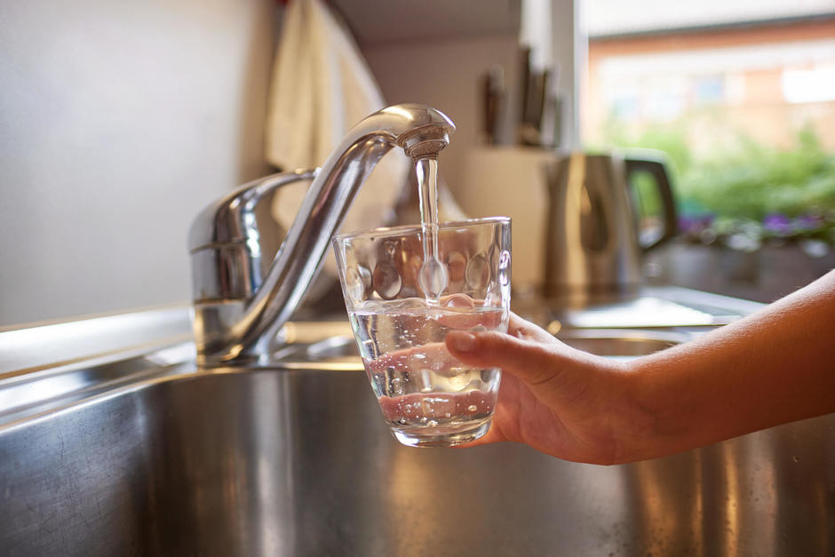 Un robinet remplit un verre d'eau