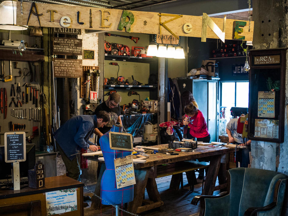 Des personnes réparent des objets dans l'atelier de René