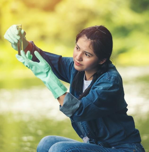 Jeune femme prélevant de l'eau pour analyse