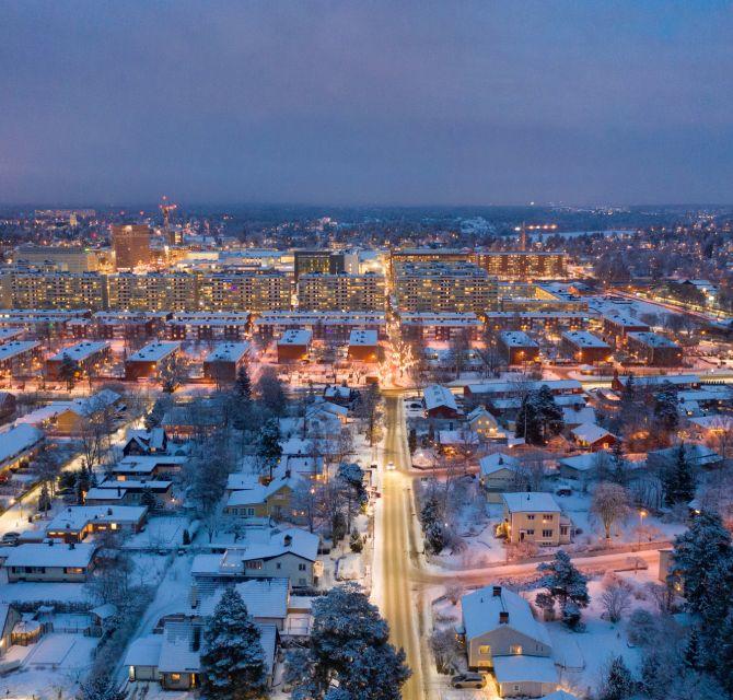 Ville éclairée sous la neige à la tombée de la nuit