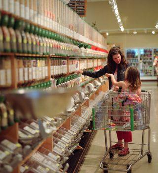 Femme avec enfant dans chariot en rayon de supermarché