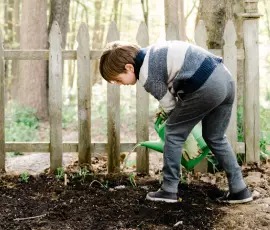 Garçon arrosant des plantes avec un arrosoir
