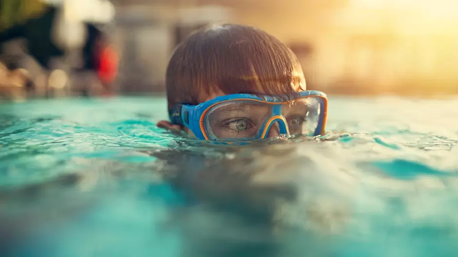 Enfant dans une piscine avec un masque de plongée