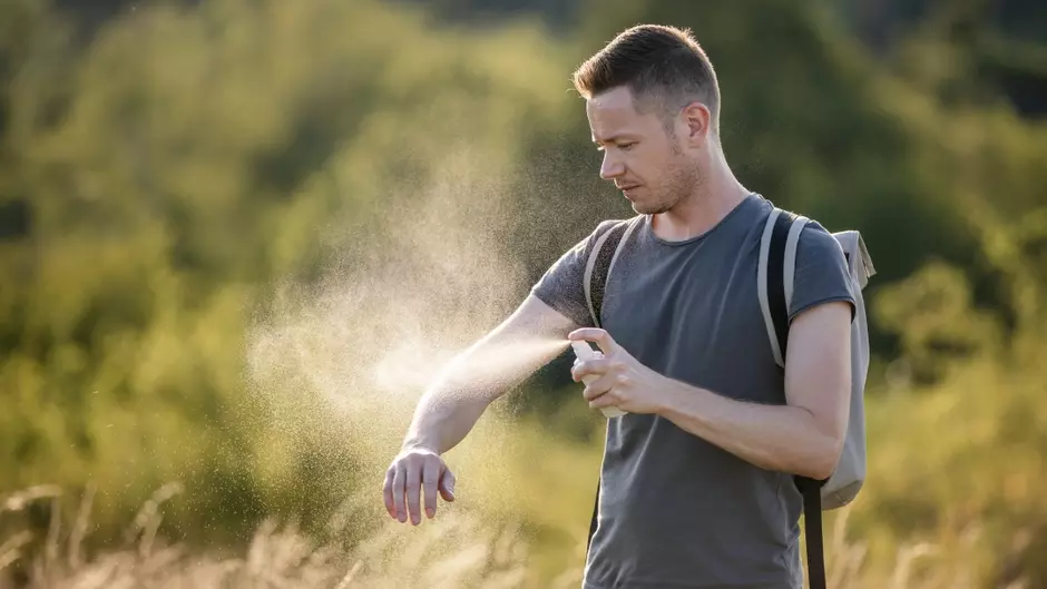 Homme s'appliquant un spray de protection contre les nuisibles